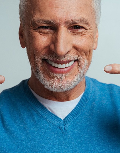 A man pointing to his dentures