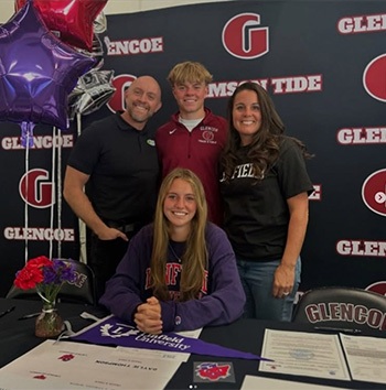 Family of four at a table at a Glencoe Crimson Tide event
