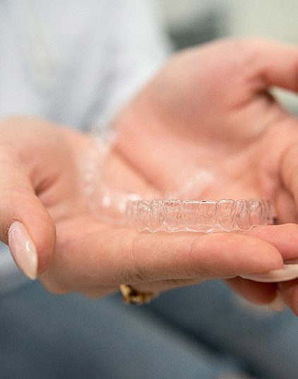 Closeup of patient holding clear aligner