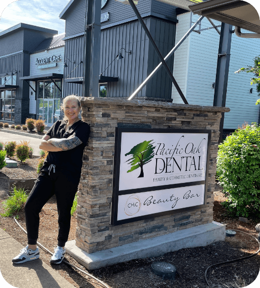 employee standing against outdoor sign