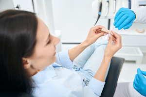 a patient examining a dental bridge model